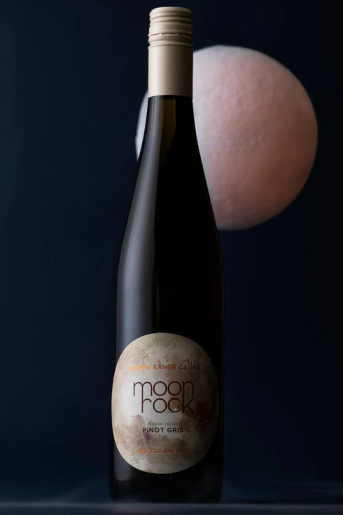 long thing bottle of white wine with moon in the background